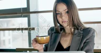 关心的女人<strong>喝咖啡</strong>，在笔记本电脑上工作，看着办公室里<strong>思考</strong>解决问题。 严重